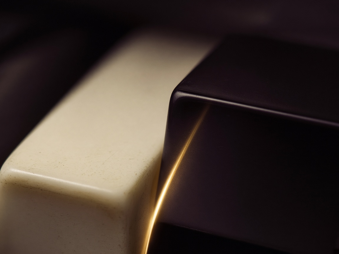 Two piano keys with a thin line of gold light between them.